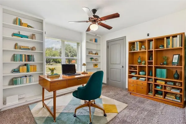 a view of a livingroom with furniture and a bookshelf