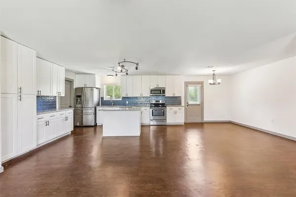 a view of kitchen with refrigerator sink and cabinets