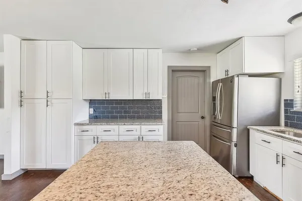 a kitchen with a refrigerator and a stove top oven