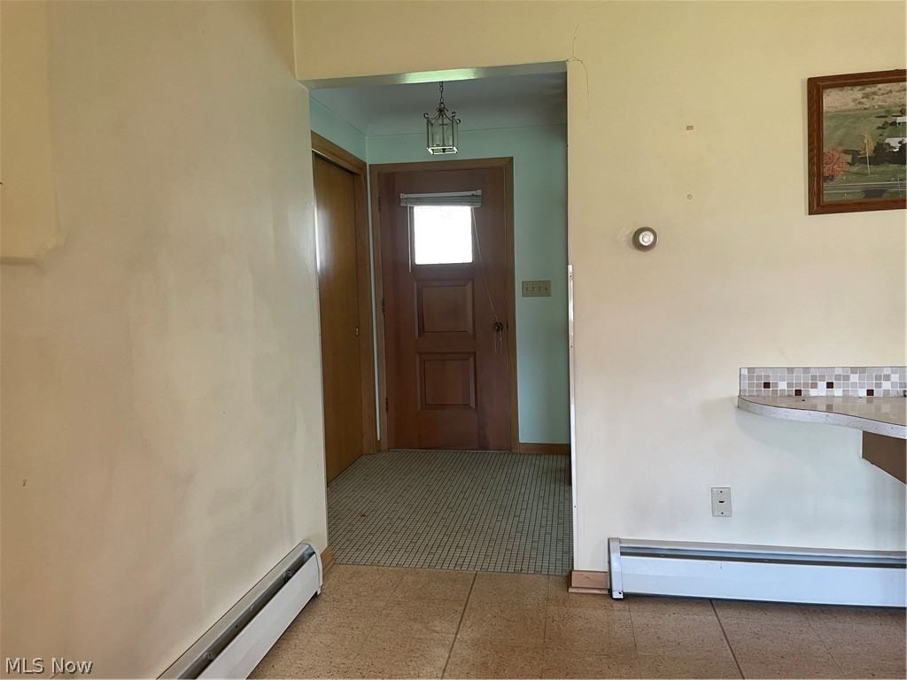 3930 State Road South Ashtabula, OH 44004 - Photo 14 of 25 Hall with a baseboard radiator and dark tile flooring