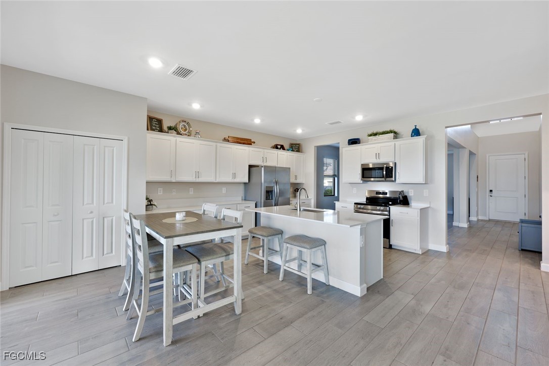 11087 Canopy Loop Fort Myers, FL 33913 - Photo 11 of 48 a kitchen with white cabinets and stainless steel appliances
