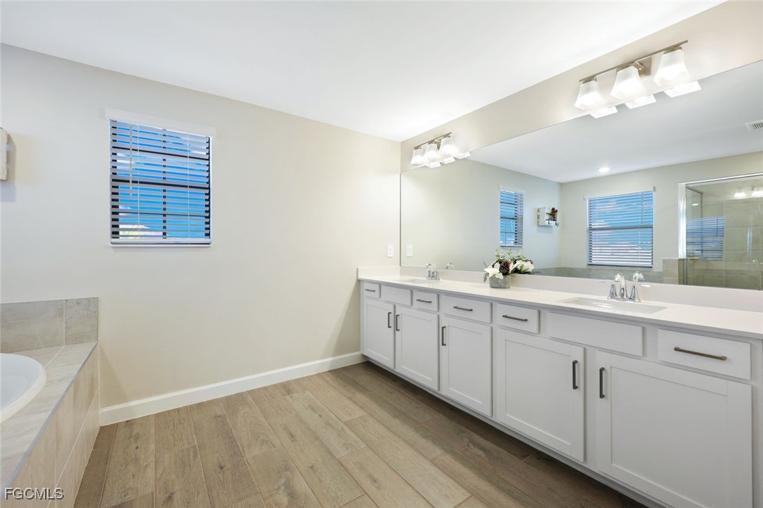 11087 Canopy Loop Fort Myers, FL 33913 - Photo 15 of 48 a spacious bathroom with a double vanity sink a mirror and a bathtub