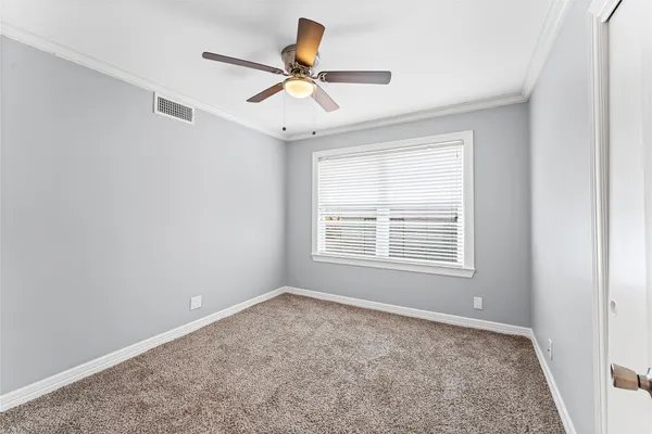 en empty room with ceiling fan and window