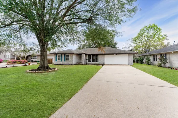a front view of a house with yard and green space