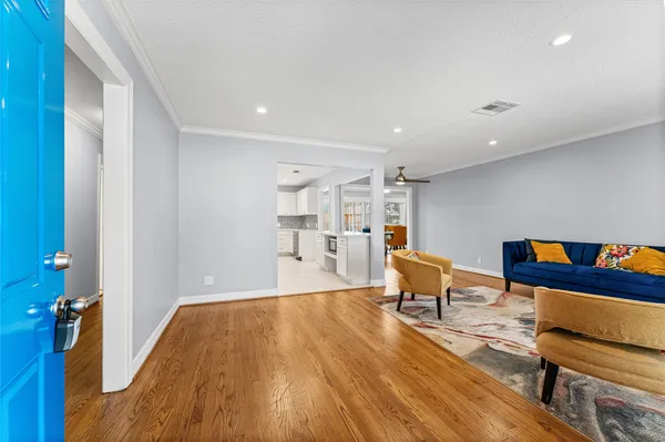 a living room with furniture and a wooden floor