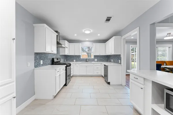 a large kitchen with cabinets and stainless steel appliances