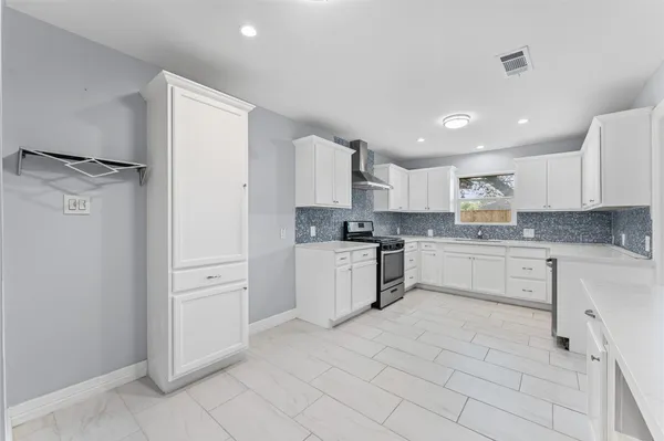 a kitchen with white cabinets and white appliances