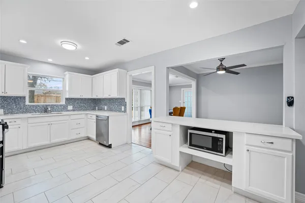 a kitchen with white cabinets and white appliances