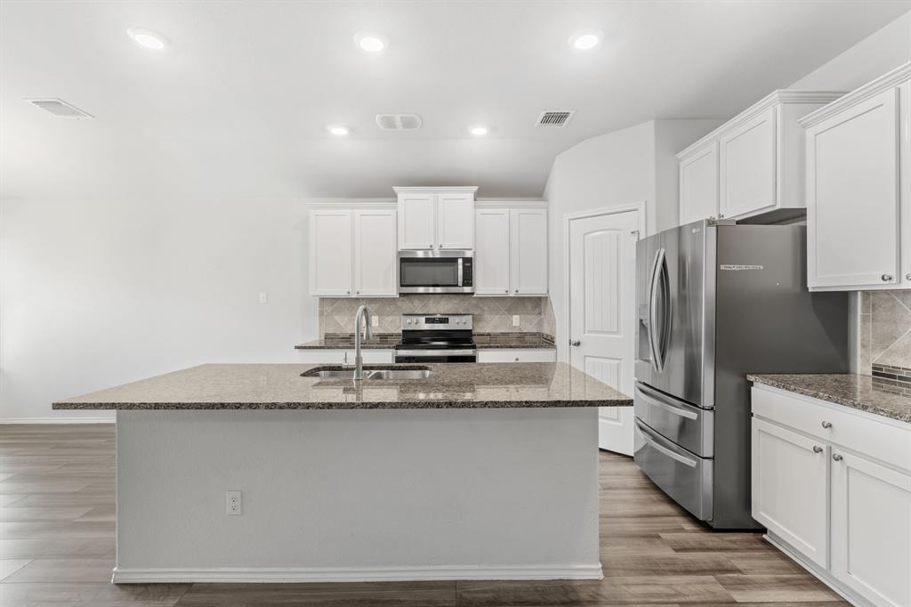 11101 Beckon Waco, TX 76708 - Photo 13 of 35 Contemporary kitchen featuring white cabinetry, granite countertops, stainless steel appliances, wood-finish flooring, and recessed lighting