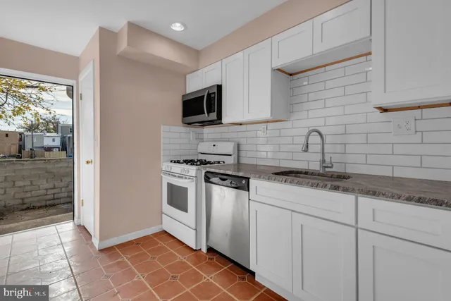a kitchen with stainless steel appliances granite countertop a sink and a stove