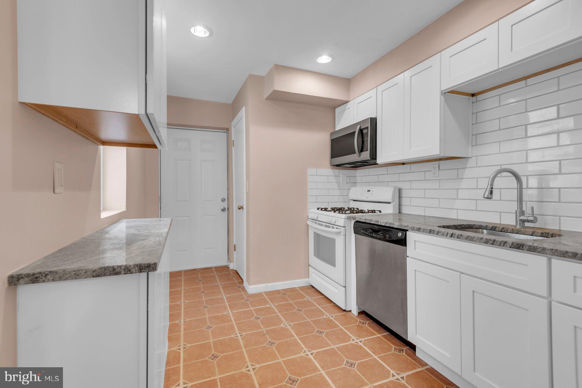 1007 East Preston Street Baltimore, MD 21202 - Photo 20 of 36 a kitchen with stainless steel appliances a sink stove and cabinets