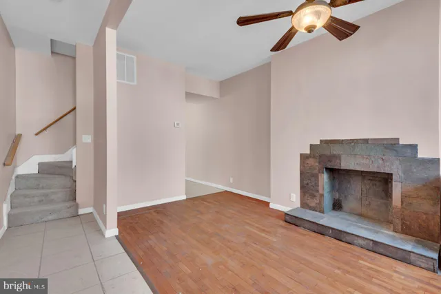 an empty room with a fireplace and fan