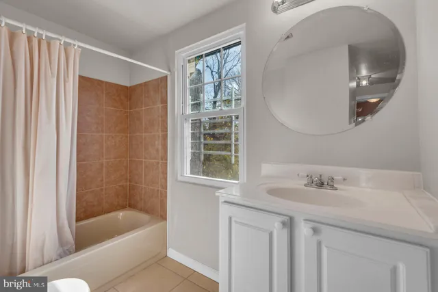a bathroom with a tub sink and mirror