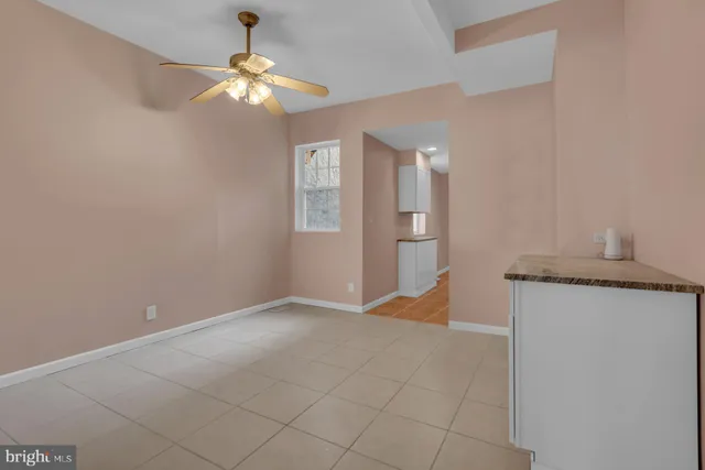 en empty room with windows and chandelier fan