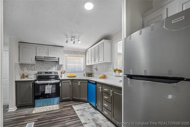 a kitchen with a refrigerator sink and cabinets