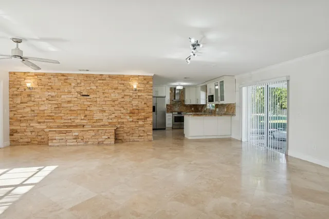 a kitchen with granite countertop white cabinets stainless steel appliances a sink and a window