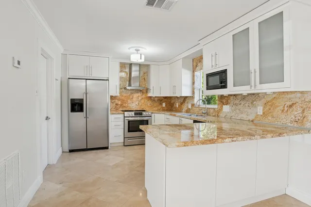 a kitchen with granite countertop cabinets stainless steel appliances and a counter space