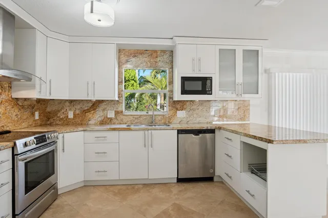 a kitchen with white cabinets and appliances