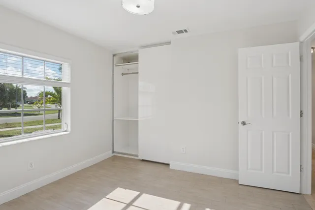 a view of a big room with windows and chandelier fan