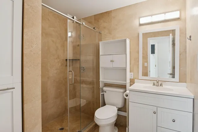 a bathroom with a toilet a sink and mirror