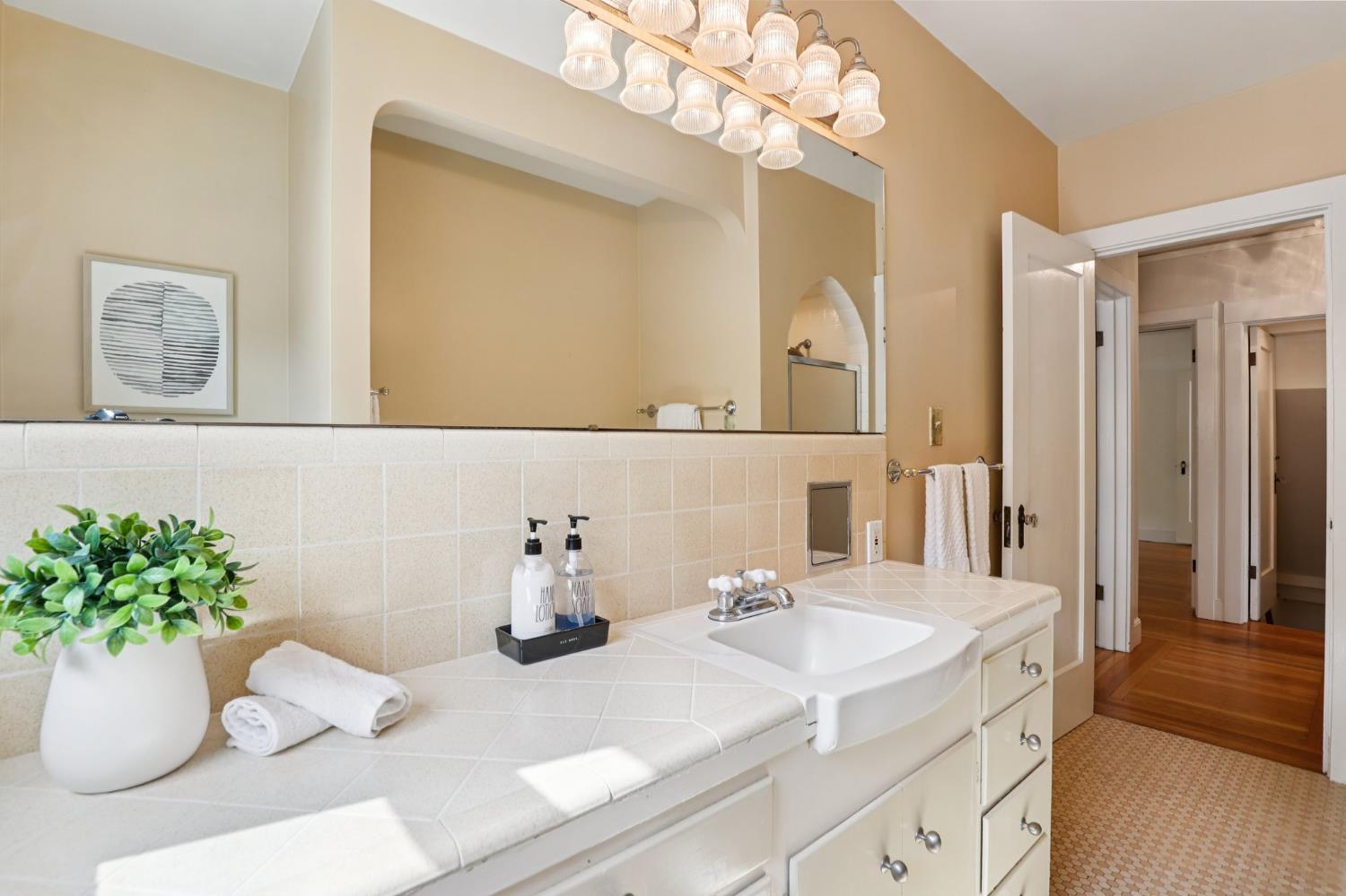 2200 2nd Avenue Sacramento, CA 95818 - Photo 36 of 69 a bathroom with a sink a mirror and a potted plant