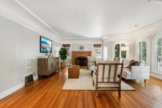 a dining room with furniture a large window and wooden floor