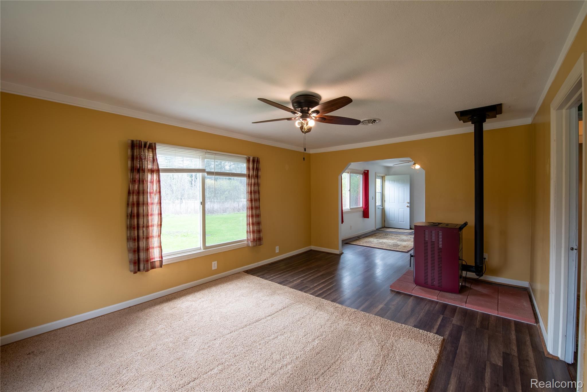 1190 Meadow Road Tawas City, MI 48763 - Photo 8 of 26 Unfurnished room with ceiling fan, dark wood-style flooring, and crown molding