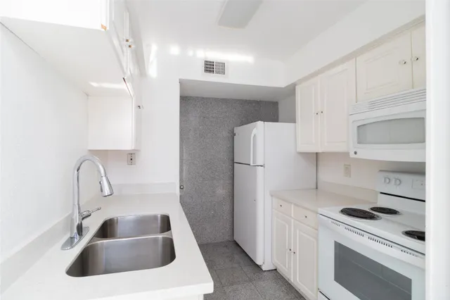 a kitchen with white cabinets and white appliances