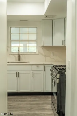 a kitchen with white cabinets and a stove top oven