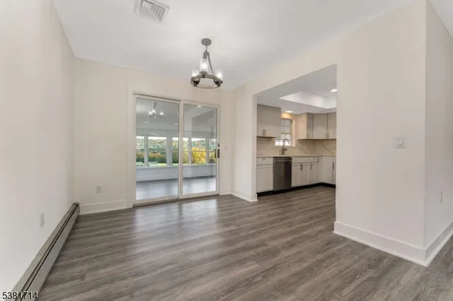 a view of a kitchen with a sink and dishwasher a refrigerator with wooden floor