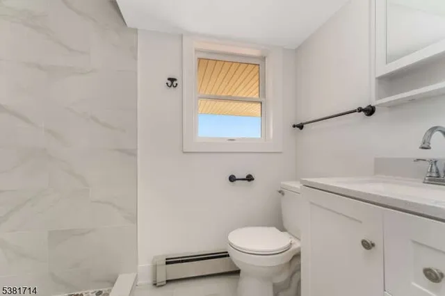 a bathroom with a sink a toilet and a window