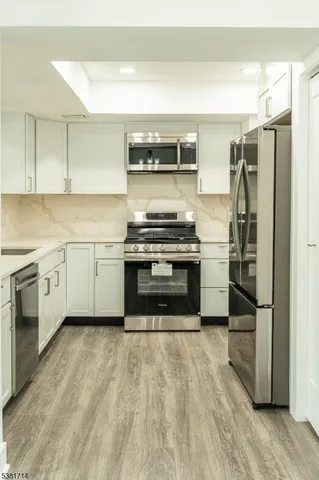 a kitchen with stainless steel appliances a stove a sink and a refrigerator