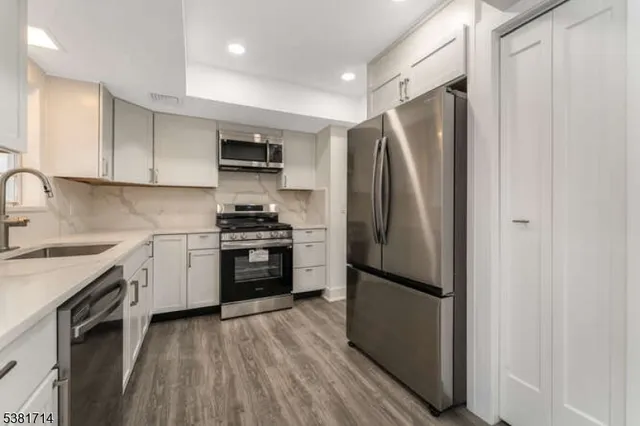 a kitchen with stainless steel appliances a refrigerator sink and microwave