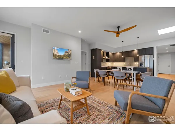 a living room with furniture and a view of kitchen