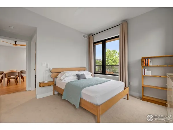 a bedroom with a bed and a view of living room