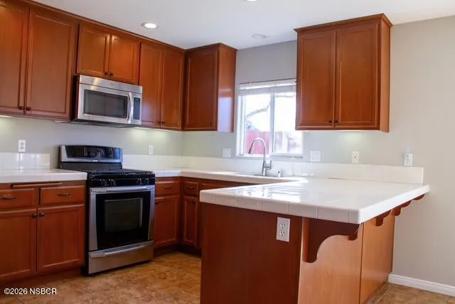 a kitchen with stainless steel appliances granite countertop a sink stove and microwave