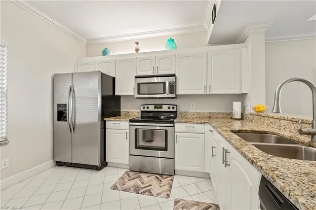 a kitchen with granite countertop a sink stove and refrigerator