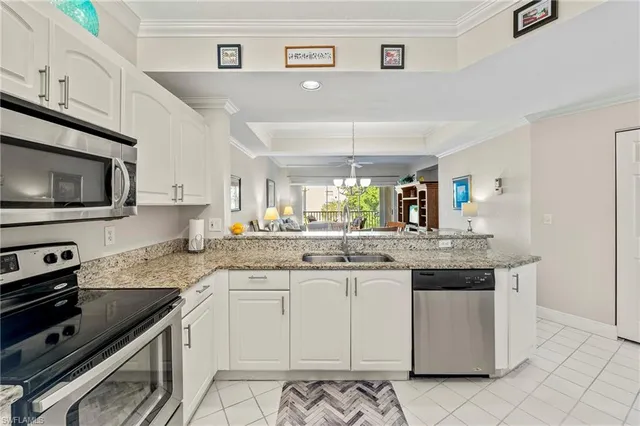 a kitchen with granite countertop a sink stainless steel appliances and white cabinets