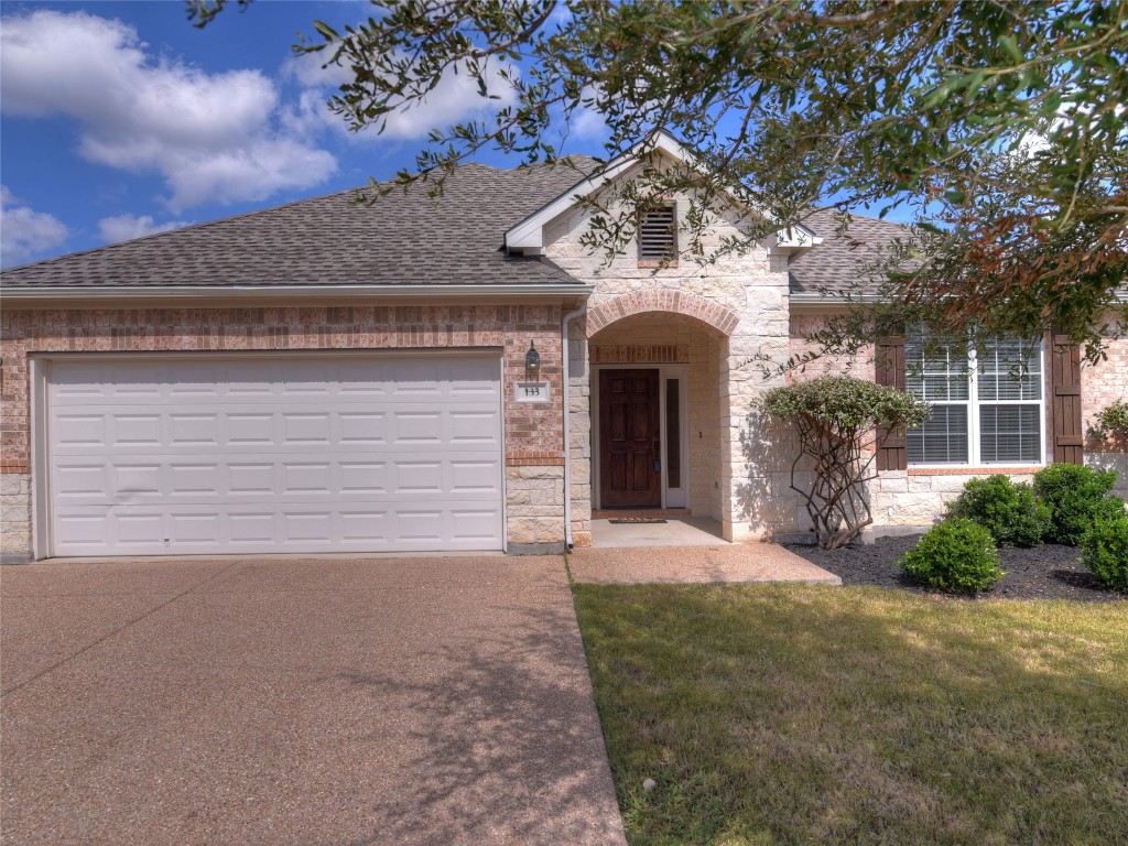 a front view of a house with a yard and garage