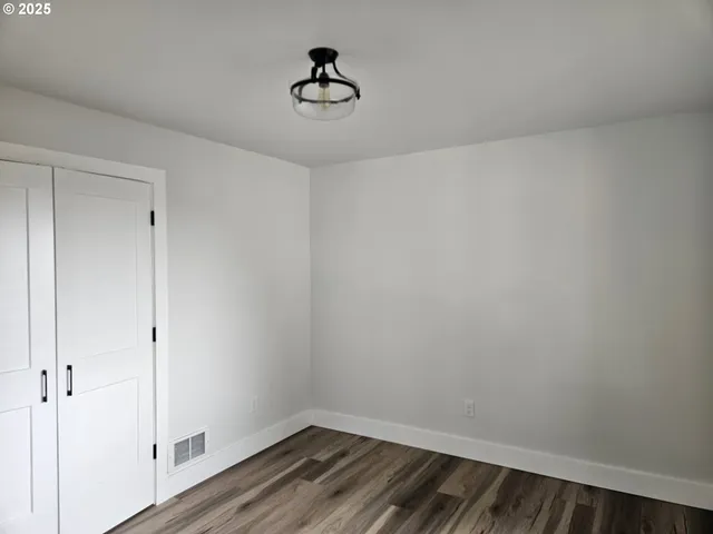 a view of wooden floor and a chandelier fan in a room