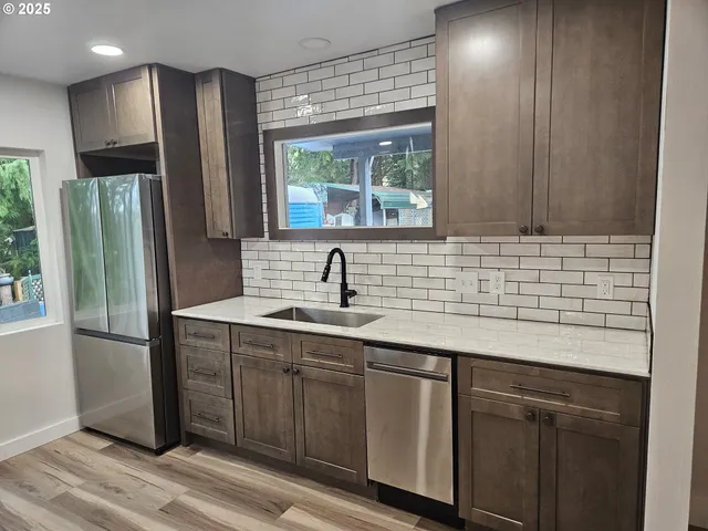 a kitchen with stainless steel appliances granite countertop a refrigerator and a sink
