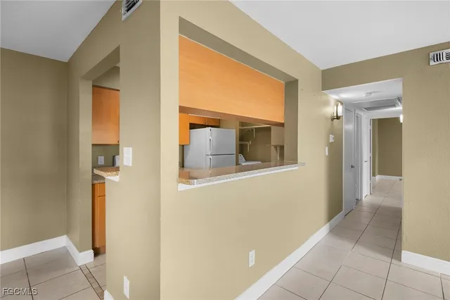 a view of a hallway with wooden floor and a living room