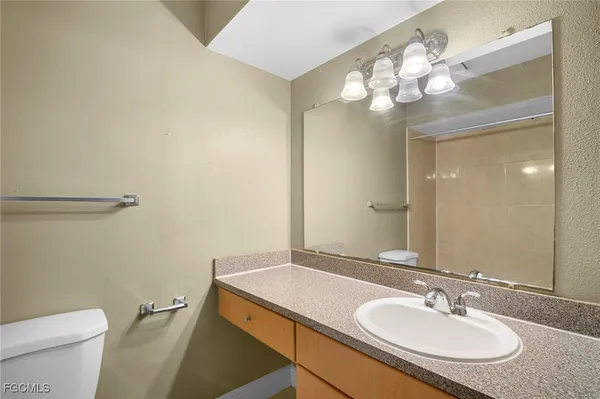 a bathroom with a granite countertop sink a toilet and a mirror