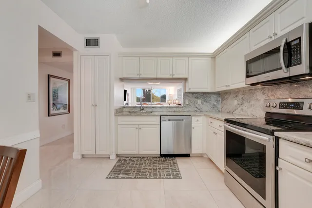 a kitchen with stainless steel appliances a stove a sink refrigerator and microwave