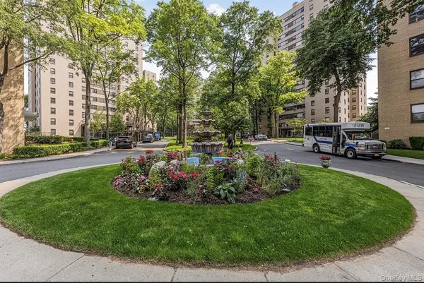 a view of a big yard with plants and a fountain