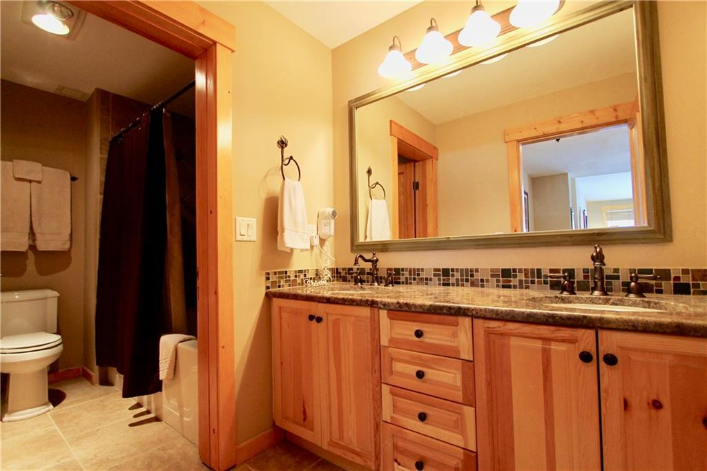 172 Copper Circle, Unit 210 Copper Mountain, CO 80443 - Photo 15 of 25 a bathroom with a double vanity sink toilet and a mirror