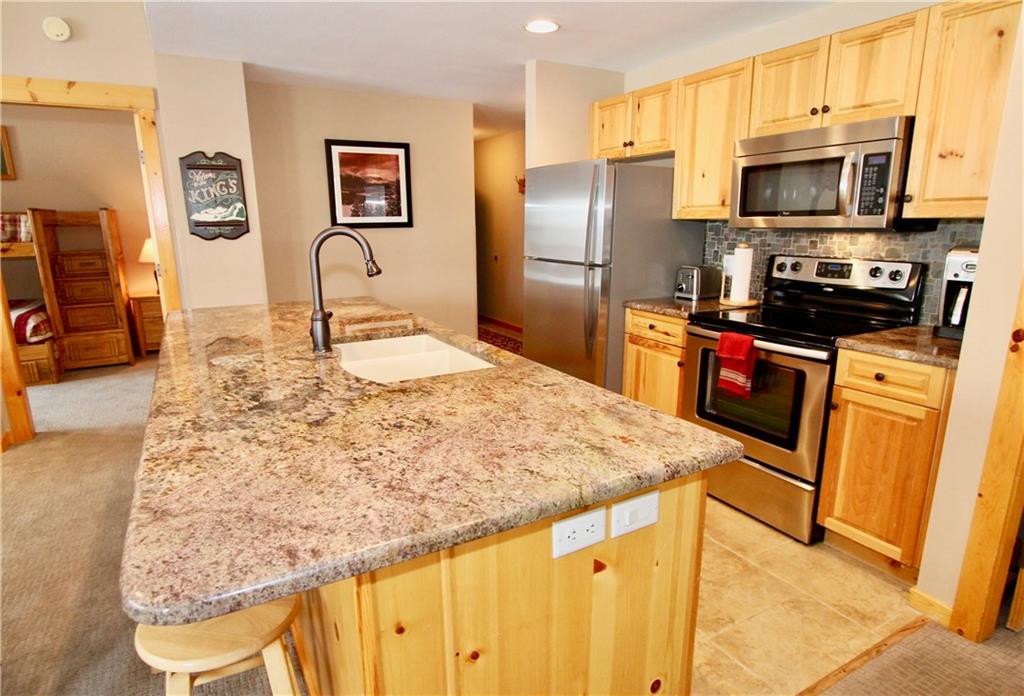 172 Copper Circle, Unit 210 Copper Mountain, CO 80443 - Photo 3 of 25 a kitchen with stainless steel appliances granite countertop a sink refrigerator and microwave
