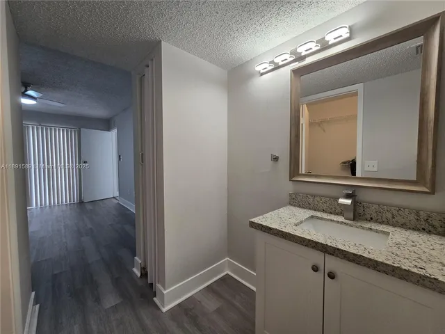 a bathroom with a granite countertop double vanity sink and a mirror