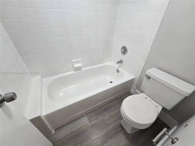 a white toilet sitting next to a bath tub