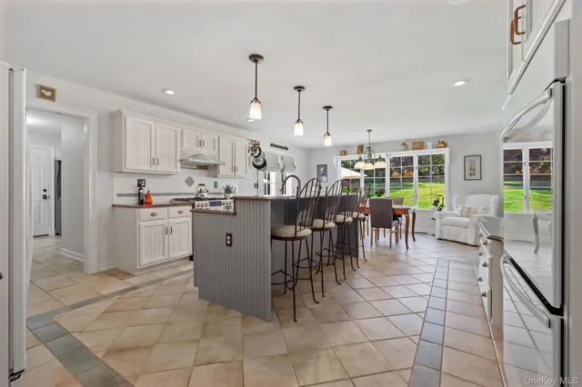 a kitchen with stainless steel appliances granite countertop a table chairs and a sink